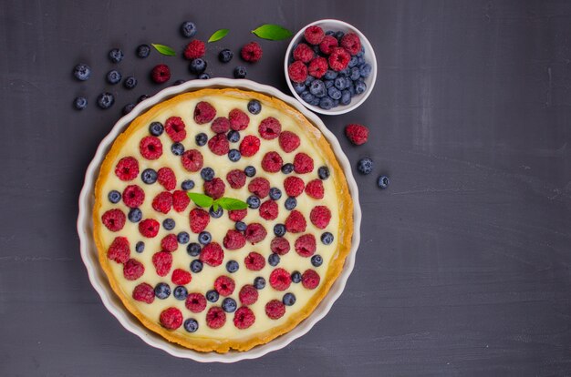 Tortino delizioso di mirtilli e lamponi con crema alla vaniglia