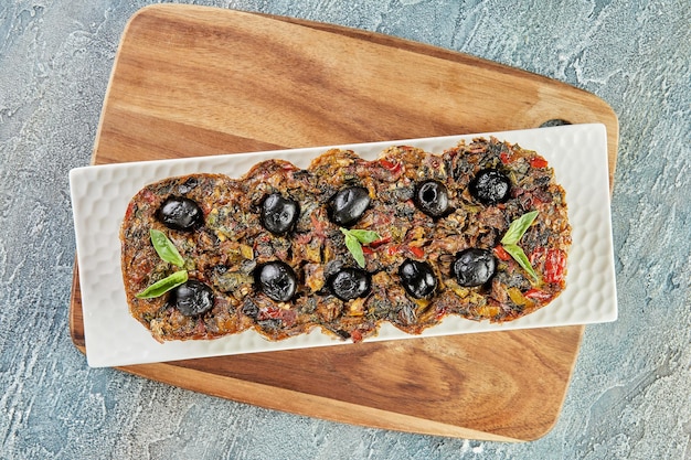 Tortino di melanzane con salsa di pomodoro e olive. Cucina gourmet francese