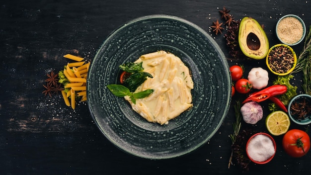 Tortino di pasta con brie. Cucina italiana. Vista dall'alto. Su uno sfondo di legno nero. Copia spazio.