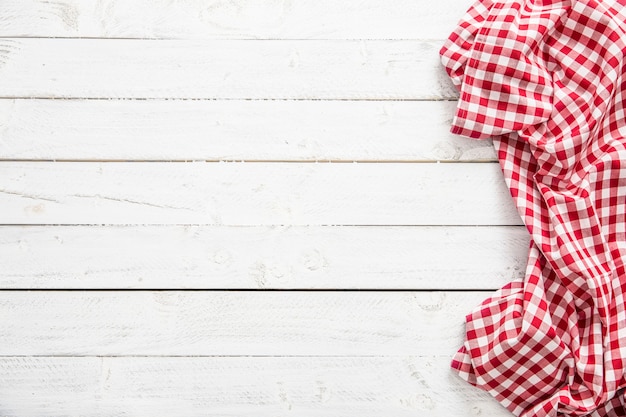 Tovaglia da cucina a quadretti rossa sulla tavola di legno.