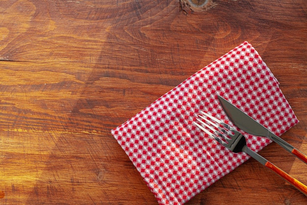 Tovagliolo o tovaglia a quadretti rosso sulla tavola di legno