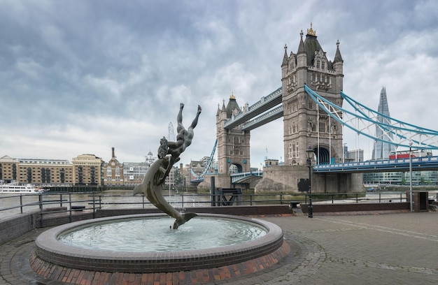 Tower bridge Ragazza e statua del delfino contro in una giornata nuvolosa