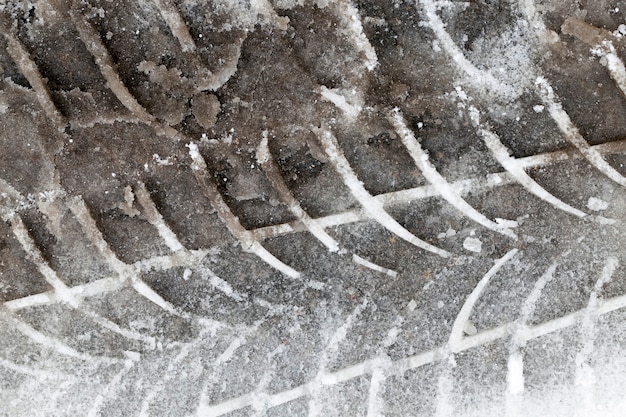 Tracce dal battistrada di un pneumatico per auto nella neve durante la stagione invernale