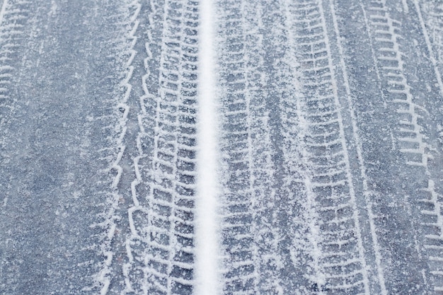 Tracce dell'auto su una strada innevata in inverno