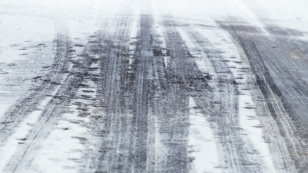 Tracce di auto sulla neve bagnata, sfondo invernale