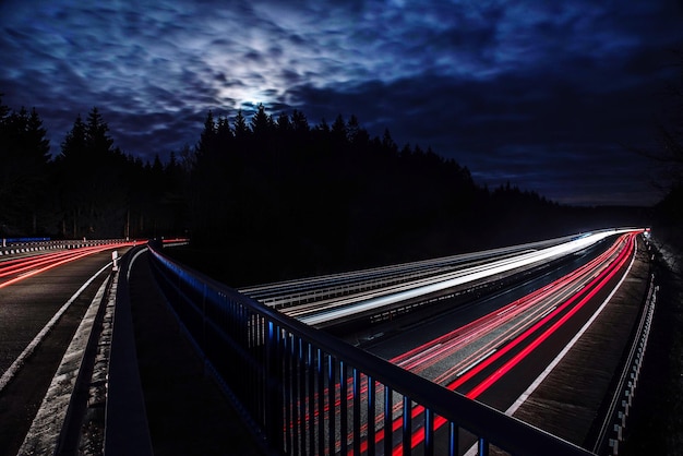 Tracce di luce sull'autostrada contro il cielo di notte