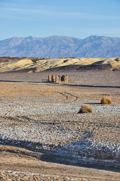 Tracce di pneumatici conducono attraverso aride pianure desertiche che portano alle montagne