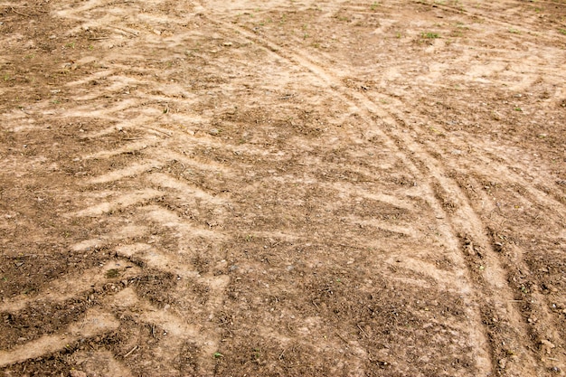 Tracce di pneumatici sulla superficie sporca come sfondo