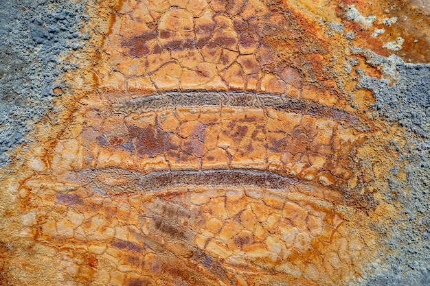 Tracce di ruote arrugginite nel fango secco della piscina, trama colorata della miniera abbandonata, vista dall'alto