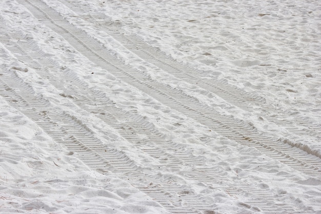 Traccia della ruota del trattore sulla spiaggia di sabbia bianca pura.