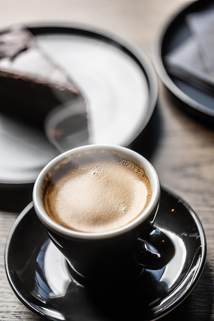 Tradizionale caffè espresso in una tazza nera su un tavolo in un caffè