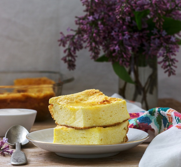 Tradizionale casseruola di ricotta rumena o moldava con farina di mais, servita con miele e panna acida.