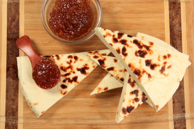 Tradizionale formaggio della Lapponia alla griglia su tagliere di legno. Formaggio stridulo dolce della Lapponia