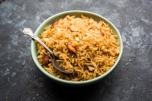 Tradizionale Jaggery Rice o Gur Wale Chawal in hindi, servito in una ciotola con cucchiaio. messa a fuoco selettiva