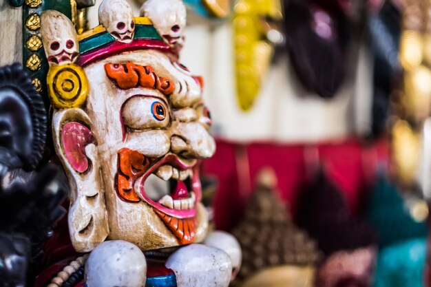 Tradizionale maschera indù rossa bhairav appesa al mercato dei souvenir