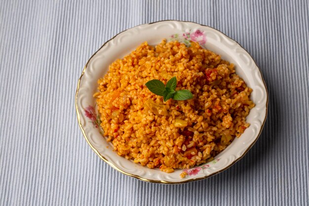 Tradizionale pilaf bulgur turco con salsa di pomodoro in piatto nome turco meyhane pilavi