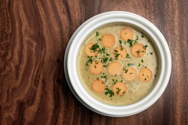 tradizionale tedesca KARTOFFELSUPPE zuppa di patate e salsiccia su tavolo di legno