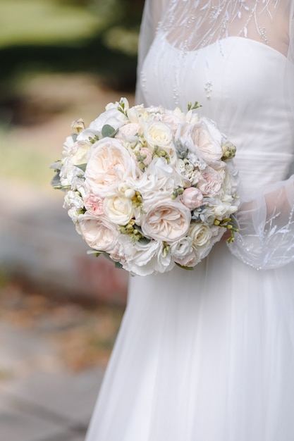 Tradizionali rose rosa chiaro e bianche disposte in un bouquet da sposaDecorazioni per feste romantiche