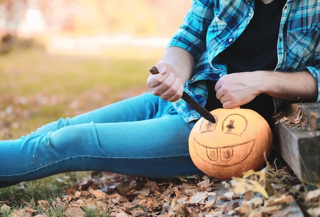 Tradizioni autunnali e preparativi per la festa di Halloween. Una casa nella natura, una lampada fatta di zucche si ritaglia a tavola.