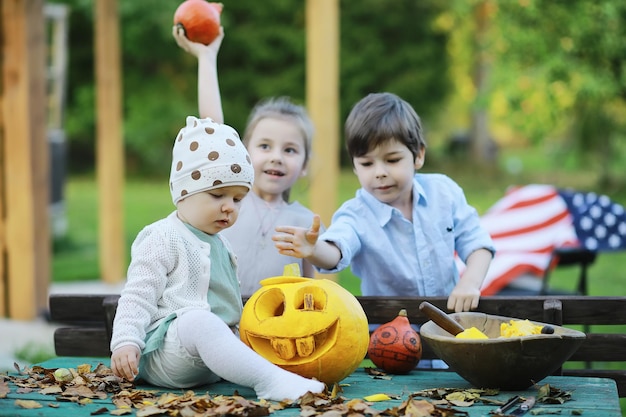 Tradizioni autunnali e preparativi per la festa di Halloween. Una casa nella natura, una lampada fatta di zucche si ritaglia a tavola.