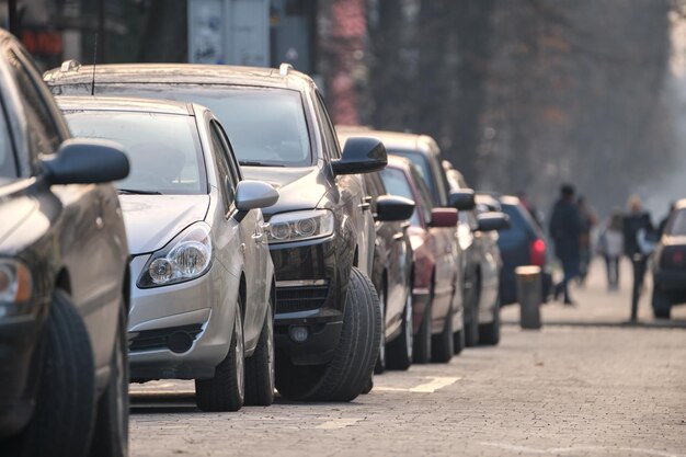 Traffico cittadino con auto parcheggiate in fila lato strada