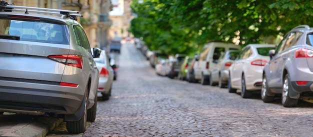 Traffico cittadino con auto parcheggiate in fila sul lato strada.