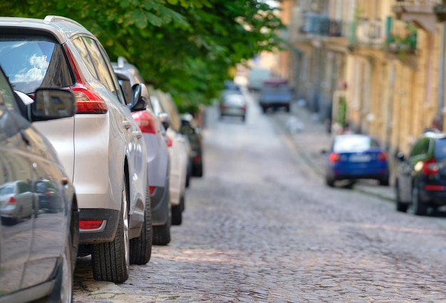 Traffico cittadino con auto parcheggiate in fila sul lato strada.