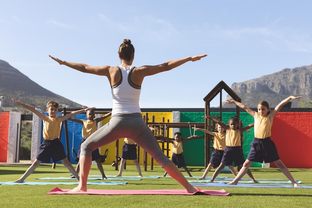Trainer che insegna yoga agli studenti nel cortile della scuola