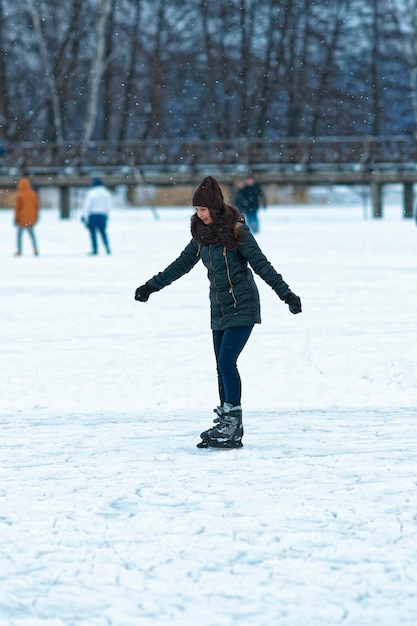 Trakai, Lituania - 17 gennaio 2016: Pattinaggio su ghiaccio della giovane donna nella pista di pattinaggio di inverno. Il pattinaggio implica qualsiasi attività che consiste nel viaggiare sul ghiaccio usando i pattini