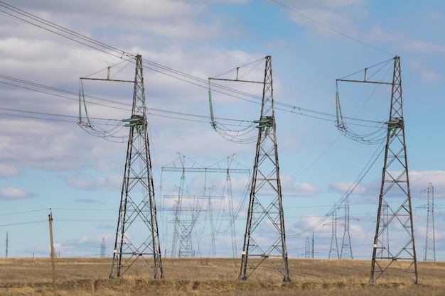 Tralicci e linee di elettricità al campo estivo, giornata di sole, teleobiettivo