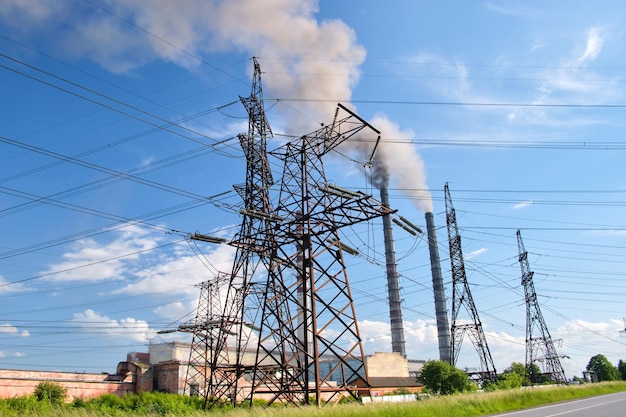 Tralicci elettrici ad alta tensione contro centrali a carbone tubi alti con fumo nero