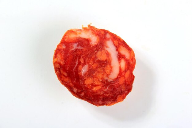 Trama di fetta di salsiccia di salame chorizo di maiale spagnolo isolata su sfondo bianco