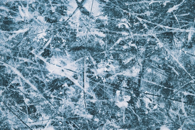 Trama di ghiaccio tono blu. Segni di pattinaggio sul ghiaccio. Pattinaggio invernale all'aperto.