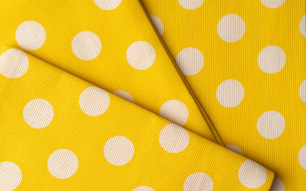 Trama di panno di tessuto di cotone giallo. Sfondo o carta da parati tessile a pois.
