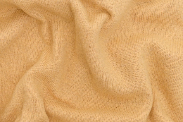 Trama di tessuto di lana stropicciato di colore giallo ocra Concetto di cashmere di lana merino Sfondo per il tuo mockup