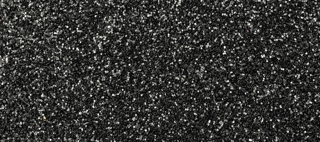 Trama glitterata nera. Priorità bassa della bandiera. Luci glitterate dettagliate, macro, astratte per capodanno, decorazioni natalizie e celebrazioni. Foto di concept design grafico