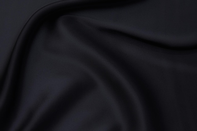Trama ravvicinata di tessuto o stoffa grigio o nero naturale dello stesso colore. Trama del tessuto di cotone naturale, seta o lana o materiale tessile di lino. Sfondo di tela nera.