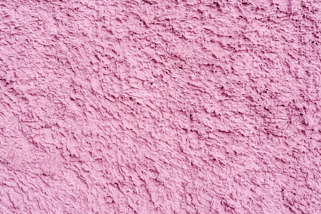 Trama rosa di intonaco irregolare sul muro della casa.