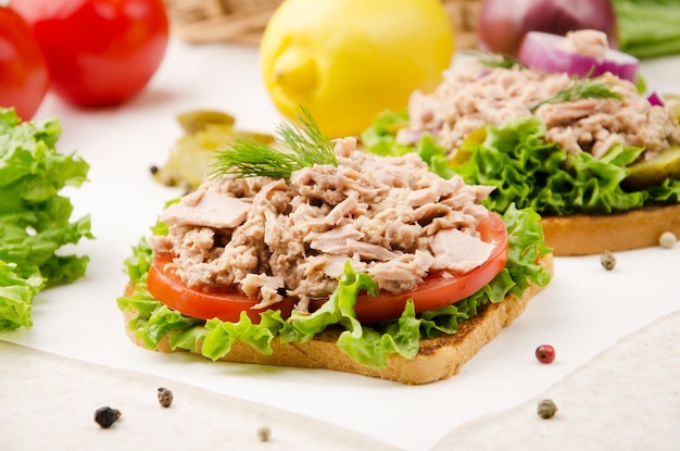 Tramezzini di tonno con lattuga, pomodori e cipolle su carta da forno