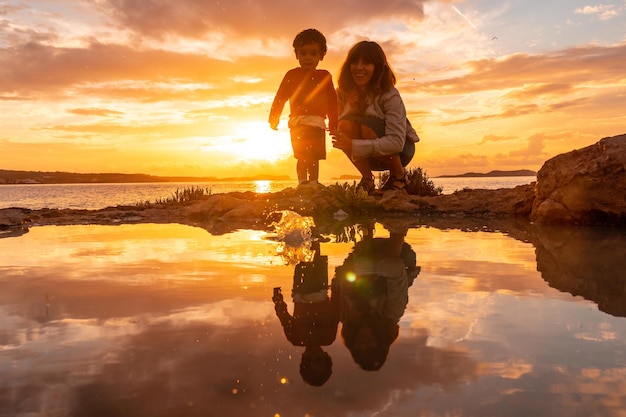 Tramonto a Ibiza in vacanza una madre con suo figlio in riva al mare a San Antonio Abad Baleari