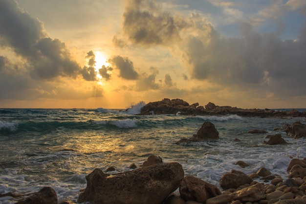 Tramonto al mare con rocce.