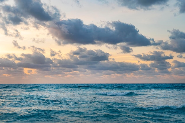 Tramonto alla luce della sera sulle onde del mare Paesaggio marino aperto sotto il cielo nuvoloso