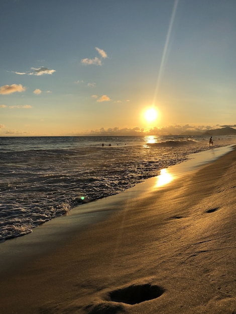 Tramonto alla spiaggia di Barra da Tijuca a Rio de Janeiro, Brasile. Mare con onde calme.