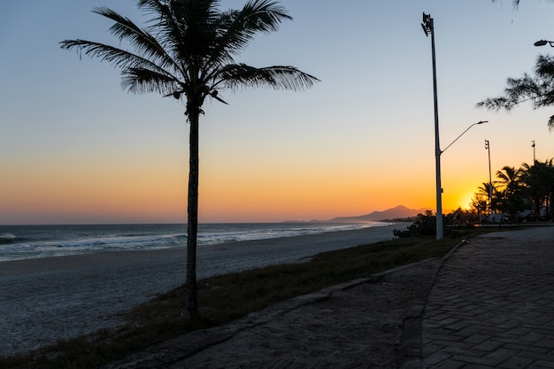 Tramonto alla spiaggia di Saquarema a Rio de Janeiro, Brasile. Famoso per le onde e il surf. Chiesa in cima alla collina.