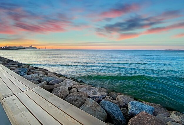 tramonto arancio dorato drammatico cielo nuvoloso di notte e riflesso dell'onda dell'acqua di mare