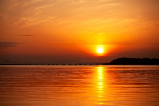 tramonto arancione sul mare oltre il ponte