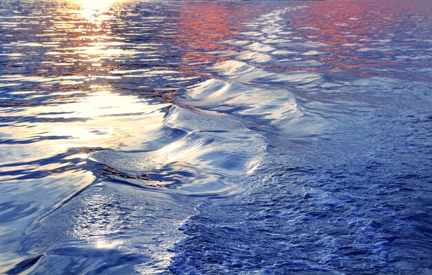 Tramonto blu delle onde di acqua di mare dalla scia della nave