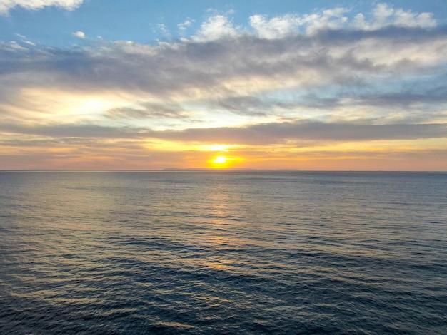 Tramonto colorato arancione sulla spiaggia dell'oceano con profondo cielo nuvoloso Bella nuvola sul mare durante il tramonto