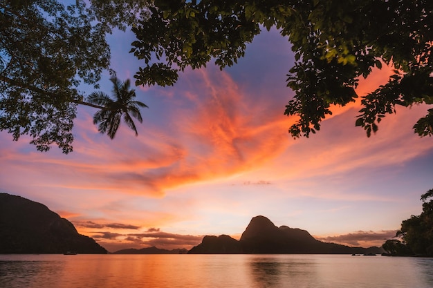 Tramonto con la silhouette di un'isola tropicale baia di El Nido Filippine