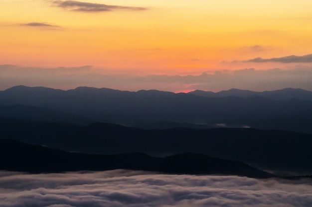 tramonto con vista sulle montagne con nebbia